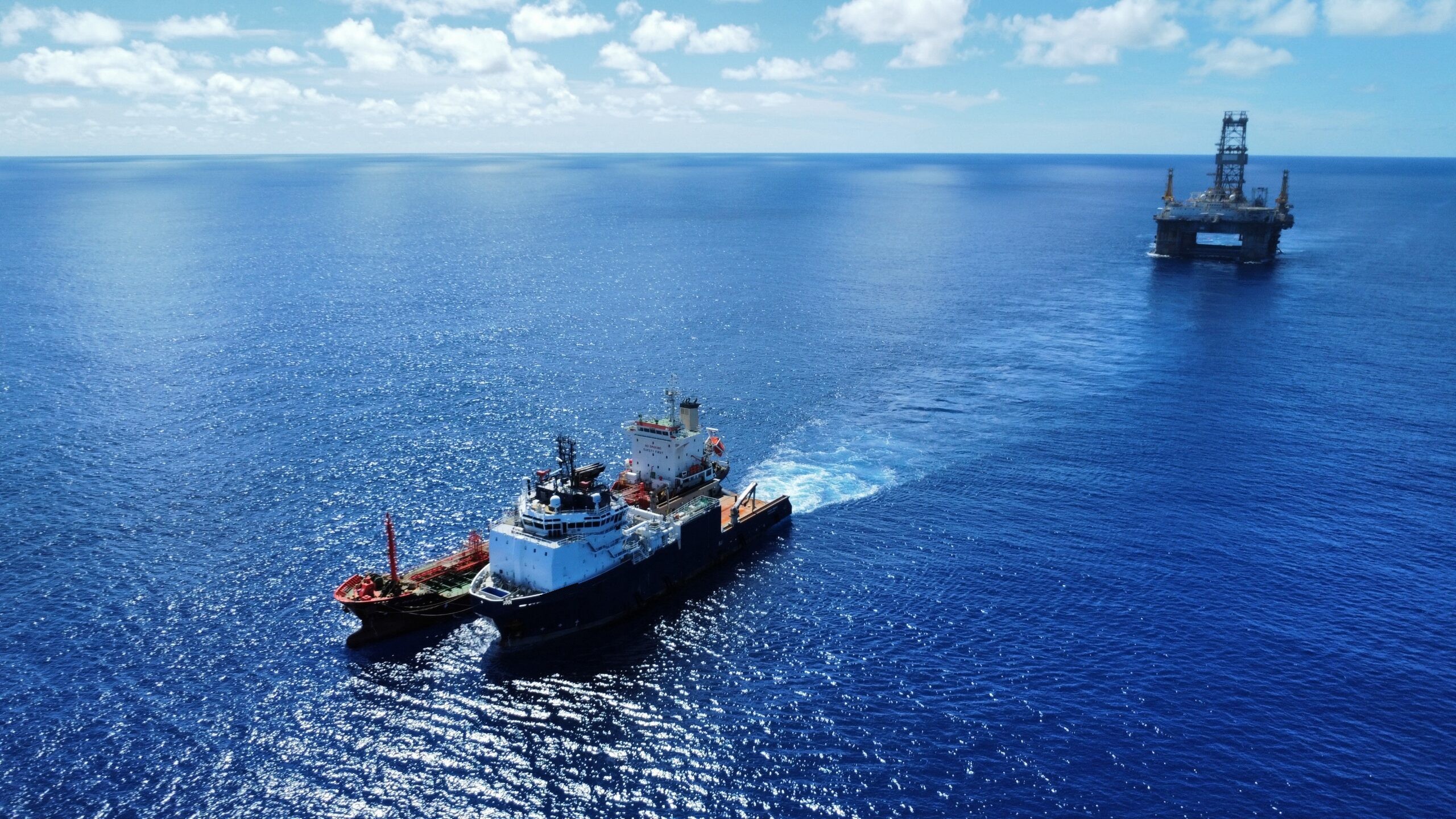 Aerial drone view of an offshore support vessel underway, leaving a wake