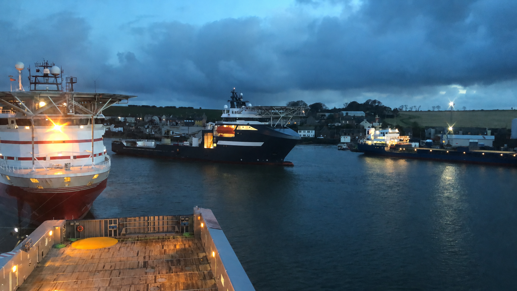 Offshore vessels moored in port at dusk