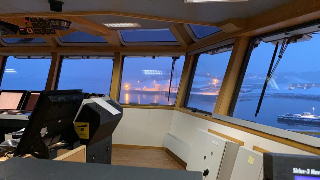View from a ship bridge overlooking the harbor through panoramic windows