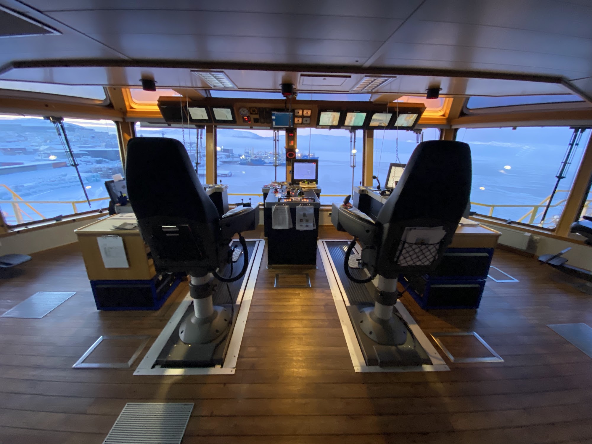 Ship's bridge with navigation consoles and pilot chairs
